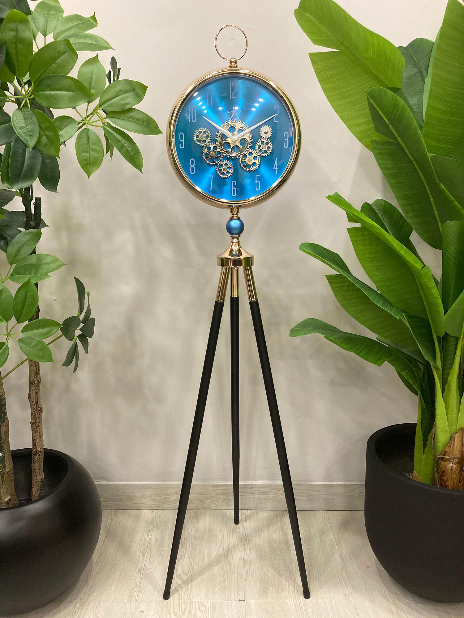 Modern unique Decorative clock on a tripod stand with plants in the background