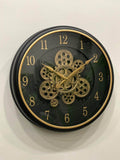 Wall clock with gold gears and numbers on a black background