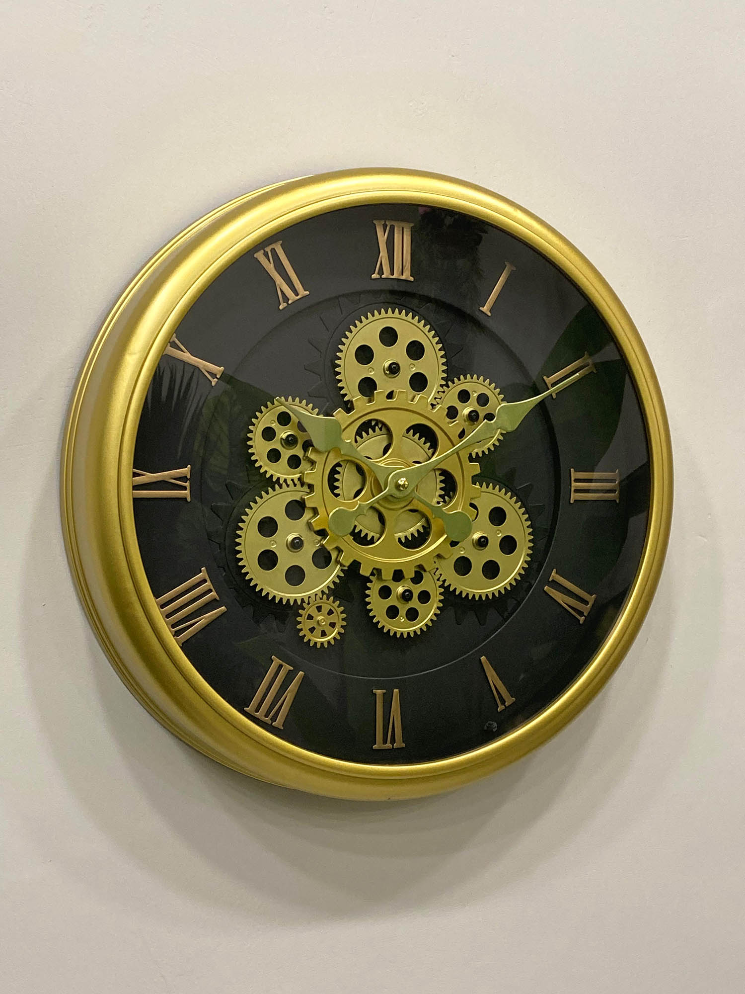Wall clock with gold gears and Roman numerals on a white background