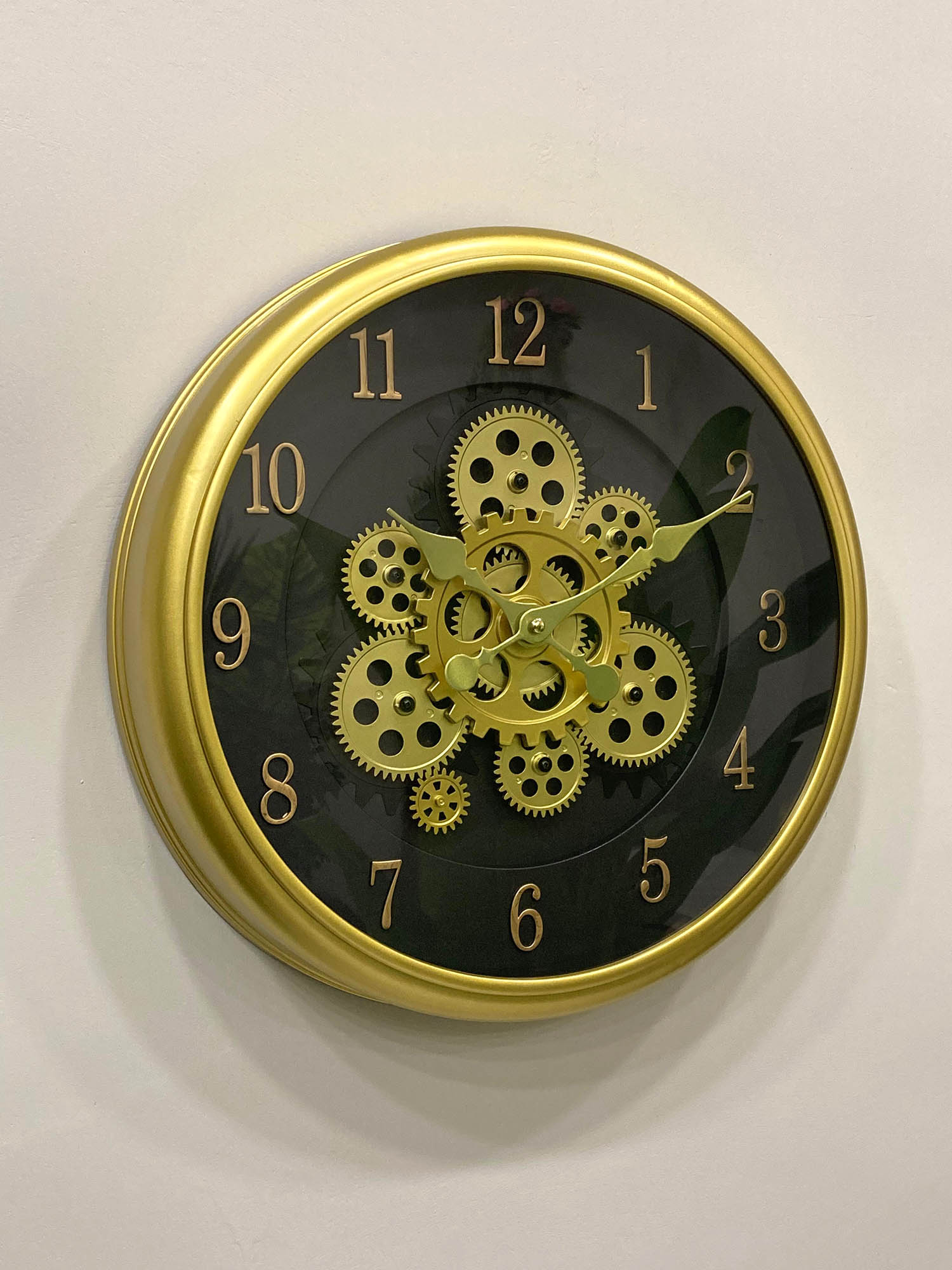 Modern wall clock for living room décor
Wall clock with gold gear design on a black face against a white background