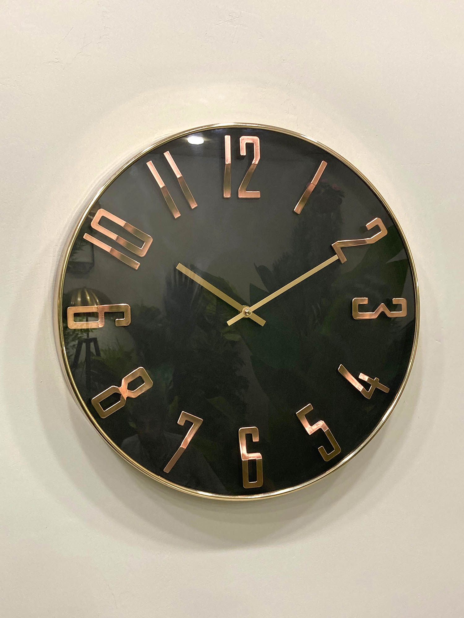 Modern wall clock for living room décor
Wall clock with gold casing and bronze Roman numerals on a white wall