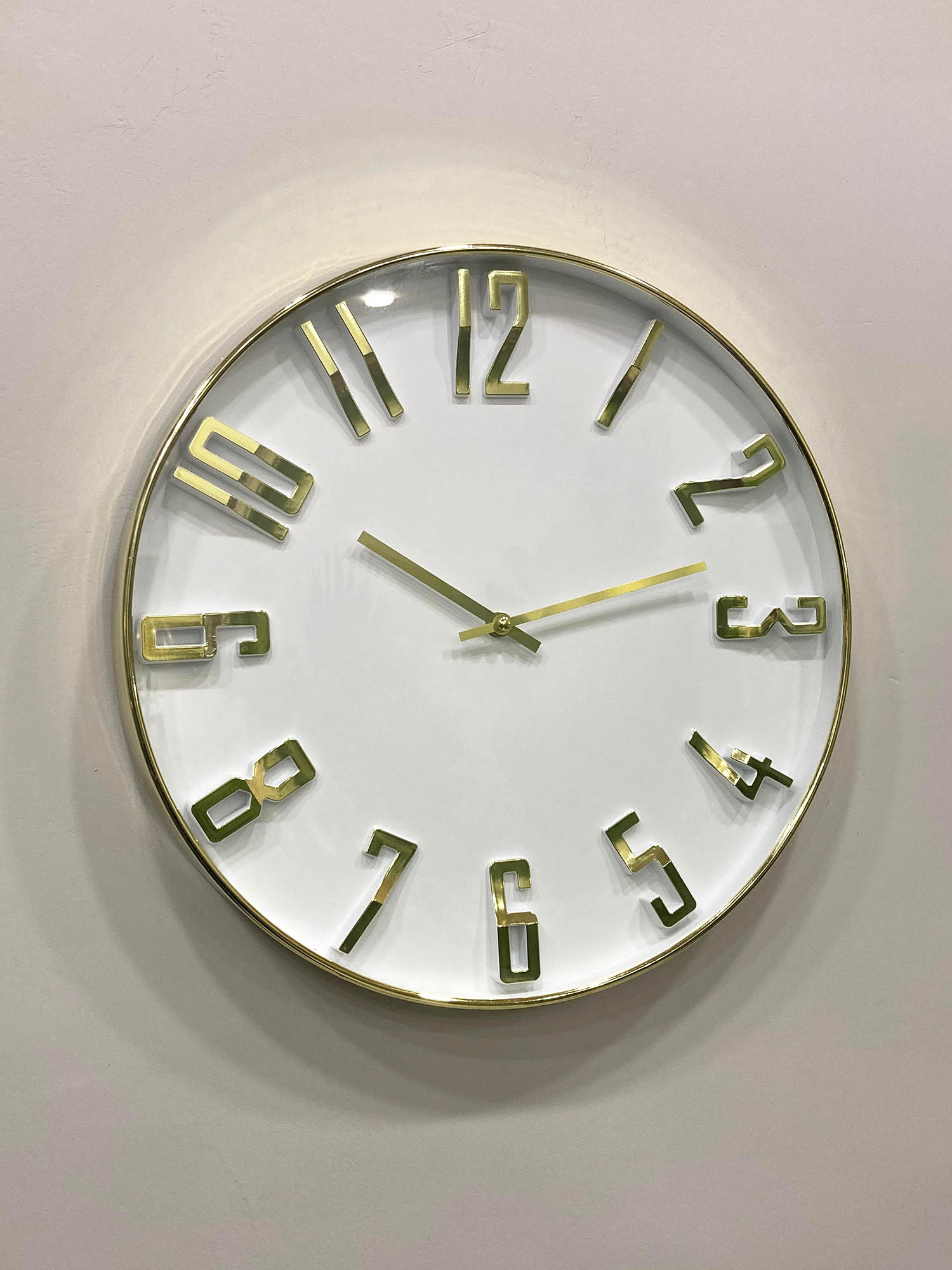 Round wall clock with gold frame and numbers on a light gray background
Modern wall clock for living room décor