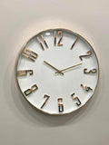Modern wall clock for living room décor 
Round wall clock with gold Roman numerals on a light gray background