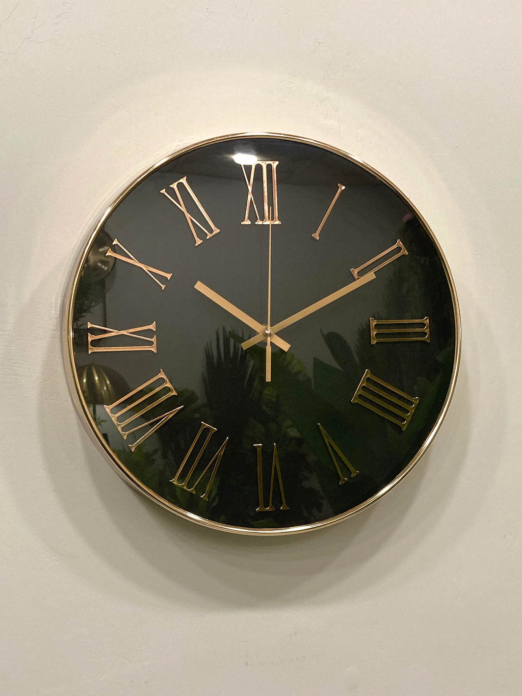 Wall clock with black face and gold Roman numerals on a white wall
Modern wall clock for living room décor