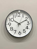 Modern wall clock for living room décor
Round wall clock with black frame and white face on a light gray wall.