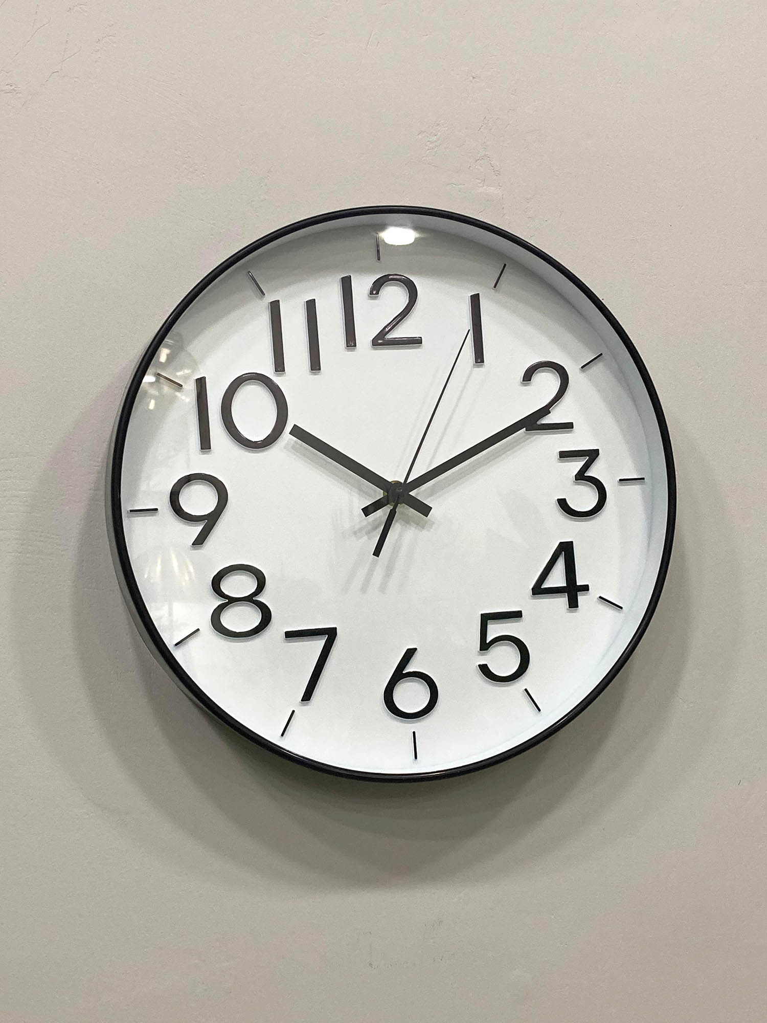 Modern wall clock for living room décor
Round wall clock with black frame and white face on a light gray wall.