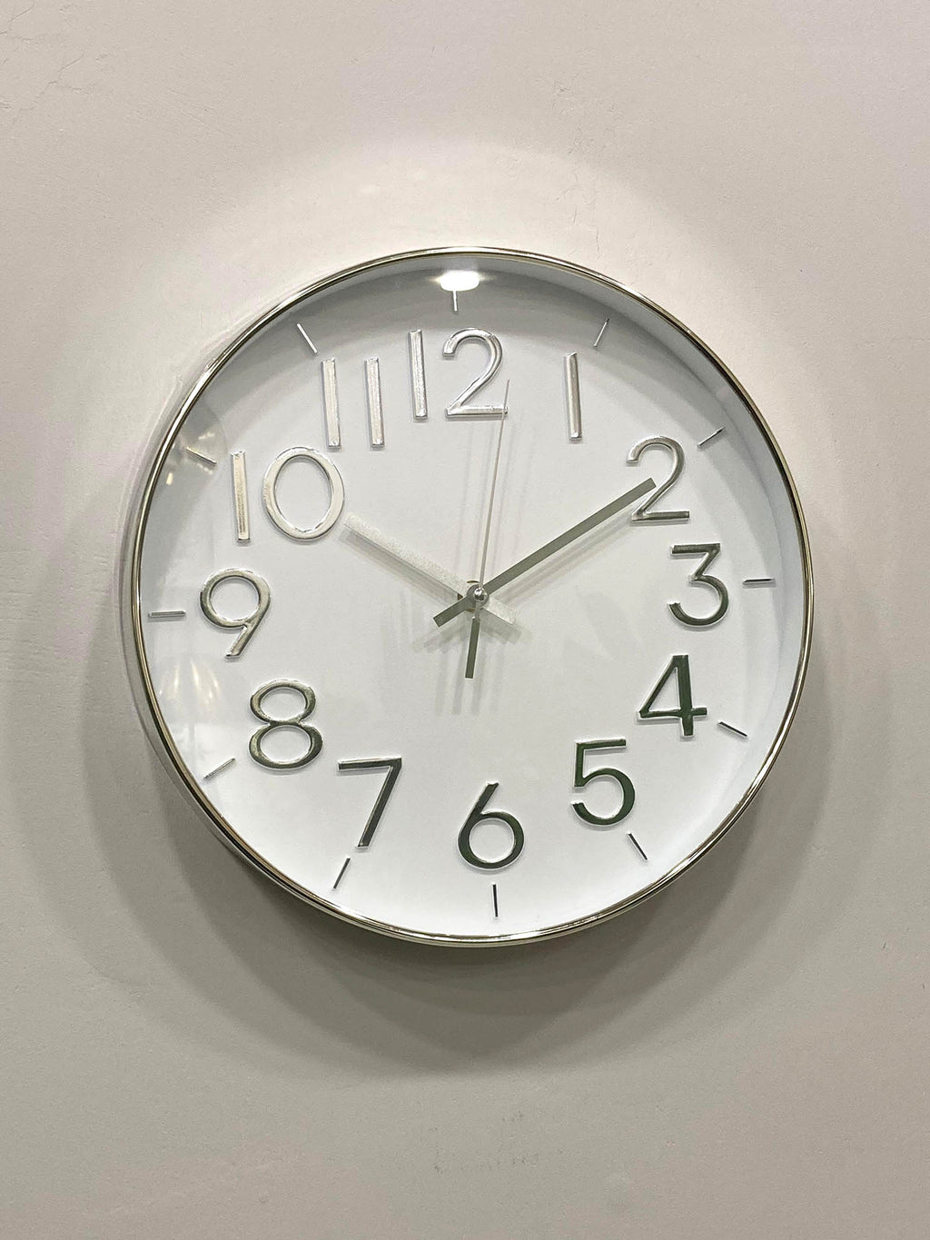 Modern wall clock for living room décor
Round wall clock with white face and black numbers on a light gray wall.