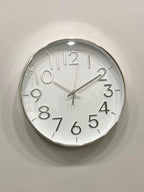 Modern wall clock for living room décor
Round wall clock with white face and black numbers on a light gray wall.
