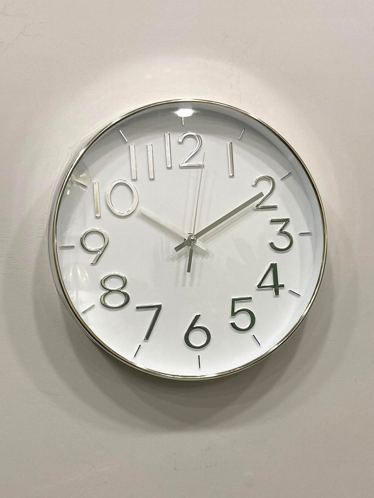 Modern wall clock for living room décor
Round wall clock with white face and black numbers on a light gray wall.