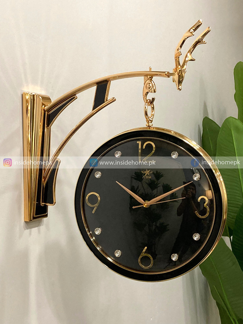 Modern wall clock for living room décor Gold and black wall clock with decorative arm on a light background