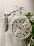 Modern wall clock for living room décor. Silver wall clock with Roman numerals on a white background