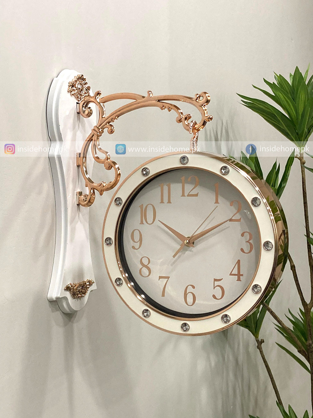 Decorative wall clock with gold and white design on a light background