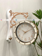 Decorative wall clock with gold and white design on a light background