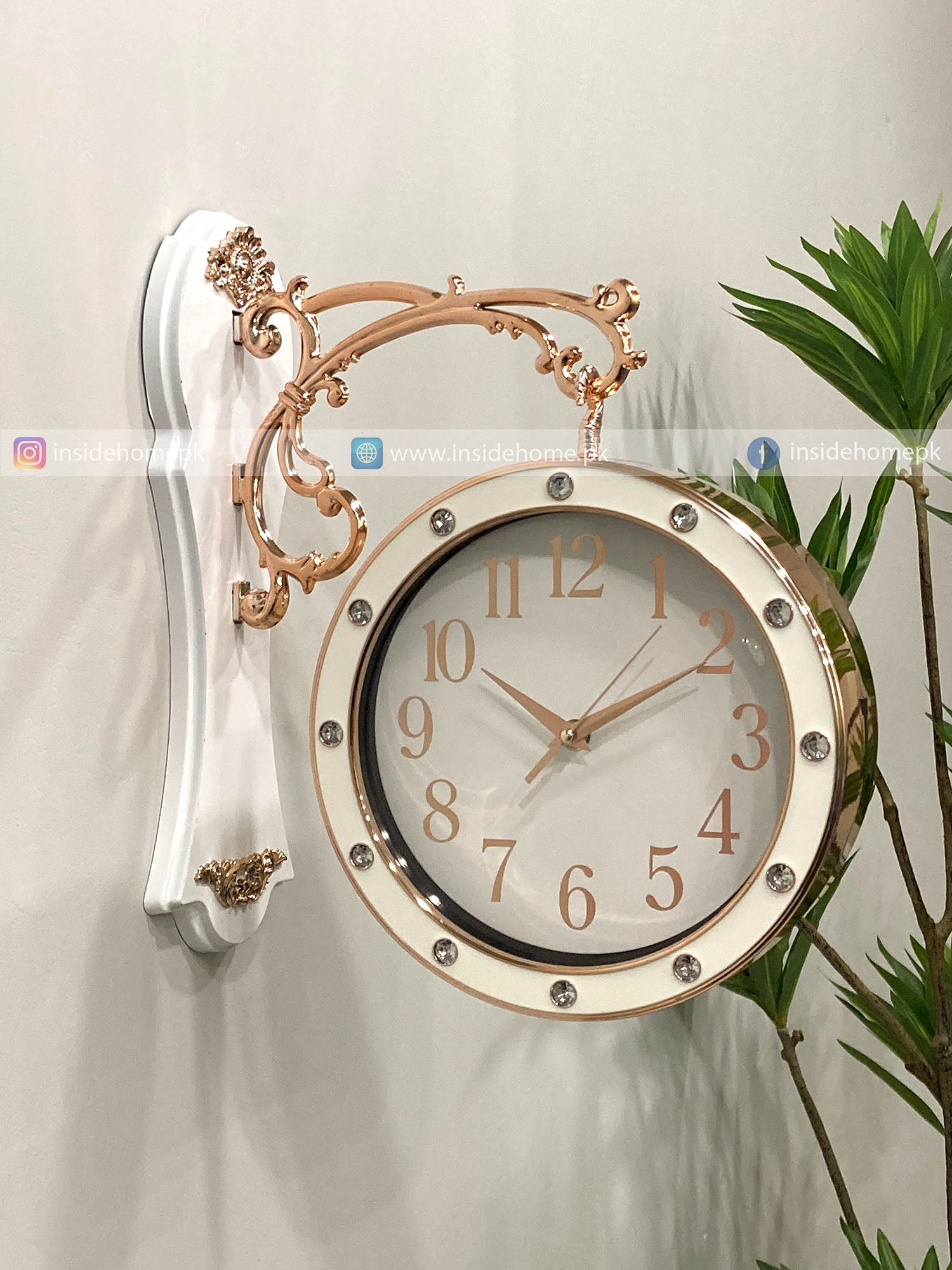 Decorative wall clock with gold and white design on a light background