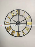 Large Modern wall clock for living room décor with gold Roman numerals on a light gray background