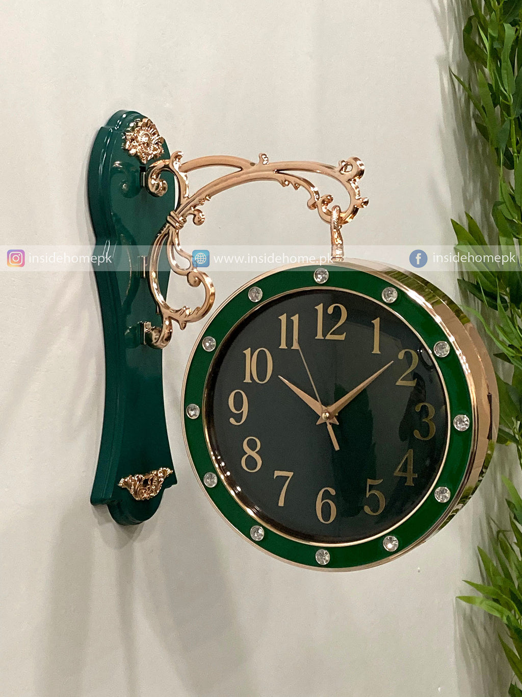 Decorative wall clock with green and gold design on a white background