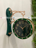 Decorative wall clock with green and gold design on a white background