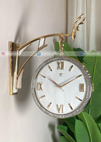 Decorative wall clock with gold frame and Roman numeral design on a light background.