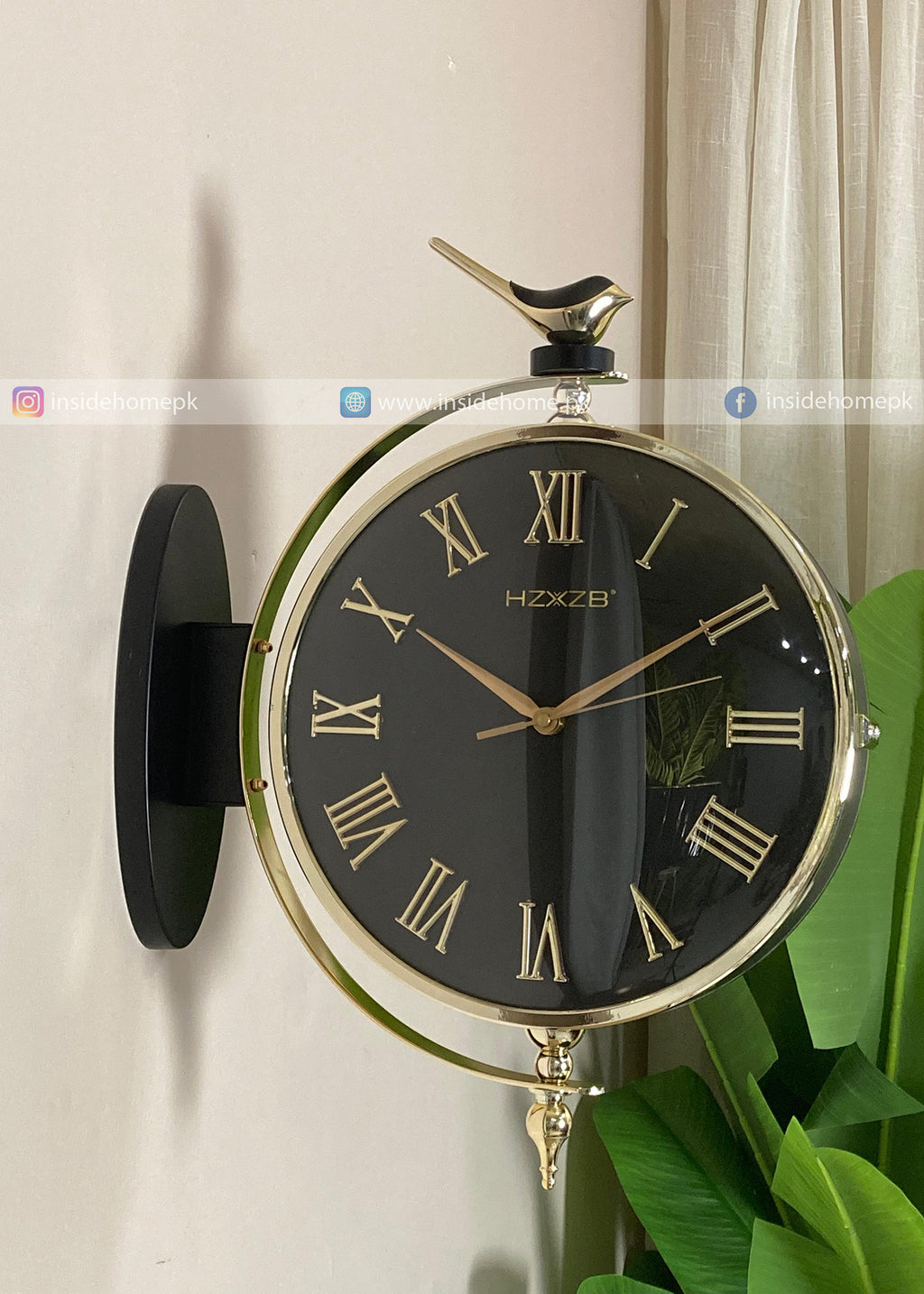 Decorative wall clock with black face and gold accents on a white wall.